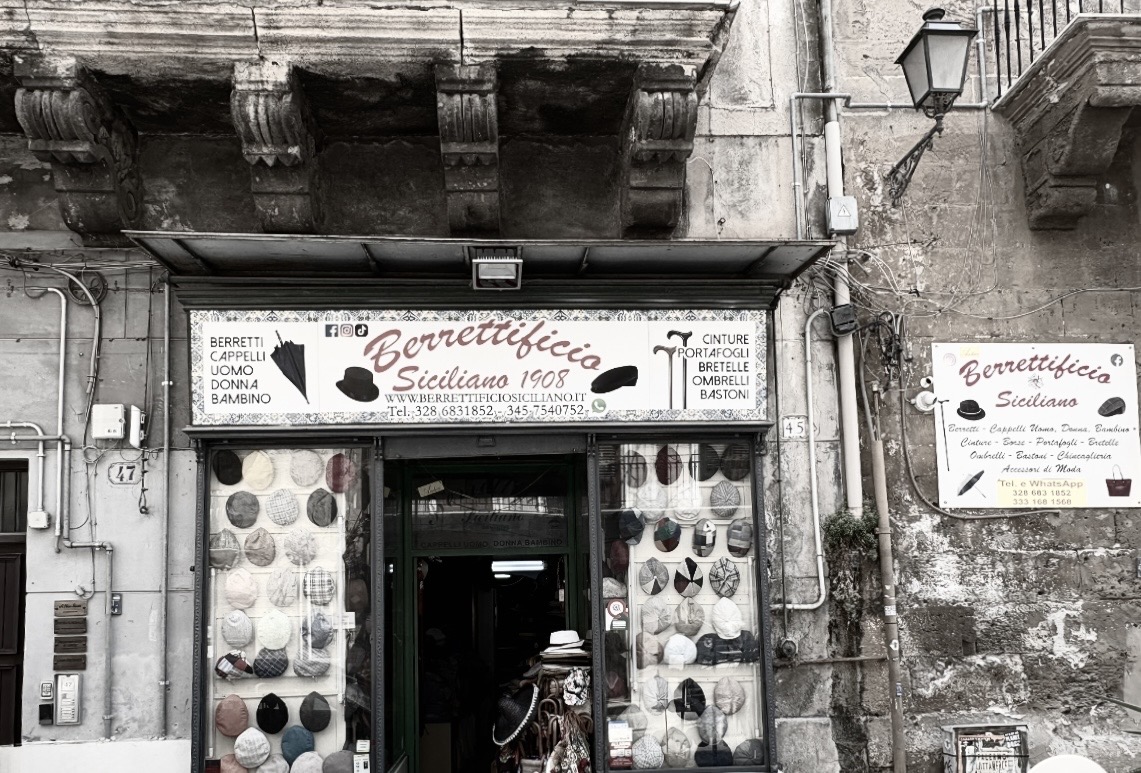 Traditional Sicilian coppola hats displayed outside a Palermo shop